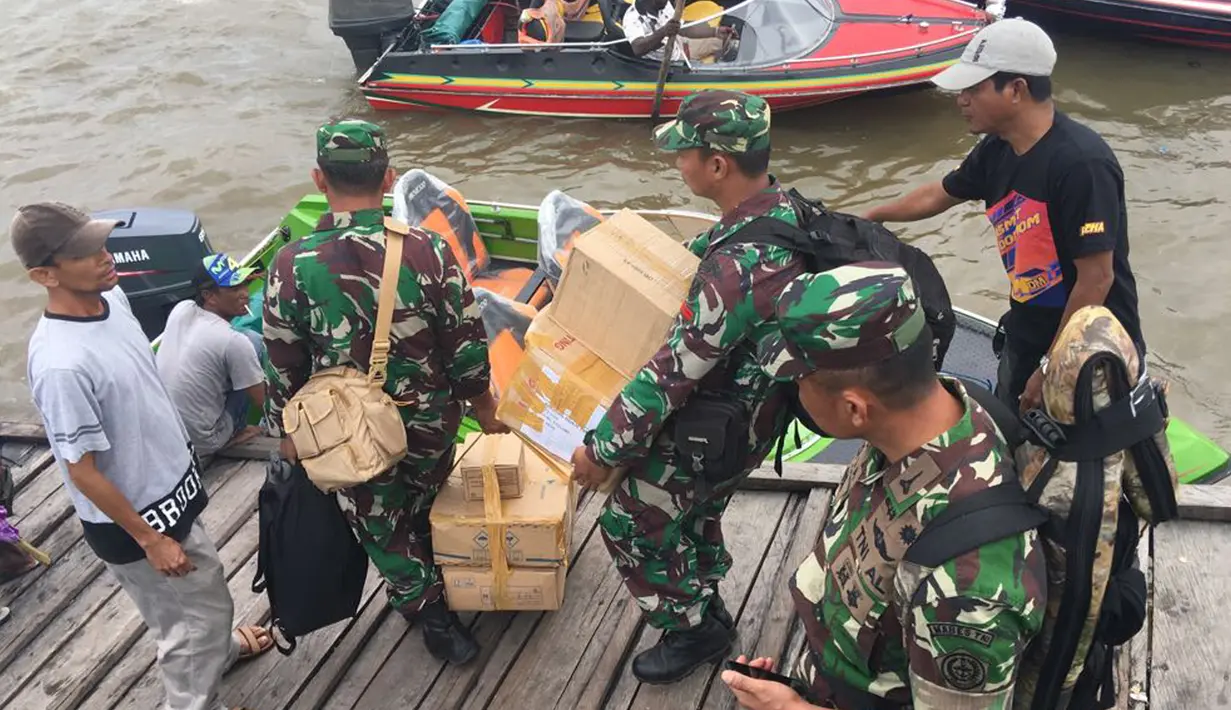 Satgas Kesehatan TNI menyalurkan bantuan berupa vaksin di Kabupaten Asmat, Papua, Jumat (19/1). Tim Kesehatan Daerah dari TNI diterjunkan ke distrik di wilayah Kabupaten Asmat menggunakan speedboat sebagai transportasi utama (LIputan6.com/Pool/Puspen TNI)