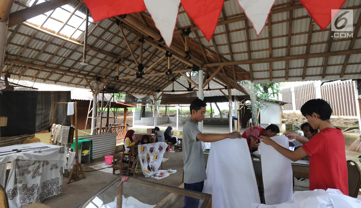 Suasana saat para perajin membuat batik cap dan tulis khas Betawi di rumah produksi Keluarga Batik Betawi, Setu Babakan, Jakarta Selatan, Minggu (10/3). Batik Betawi ini dijual seharga Rp 135  ribu hingga Rp 800 ribu per helai. (merdeka.com/Arie Basuki)