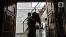 Wiwiek menggendong cucunya di depan rumahnya yang tertutup tembok bangunan sekolah di Jalan Cempaka Baru I, RT 015/003, Kemayoran, Jakarta, Senin (31/8/2020). Pembangunan itu menutup akses jalur keluar masuk dan harus melewati pintu samping. (merdeka.com/Iqbal S Nugroho)