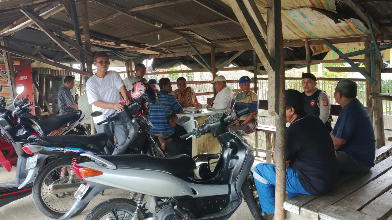 Personel Polresta Pekanbaru duduk di pangkalan ojek bersama warga dalam patroli keamanan dan ketertiban masyarakat.