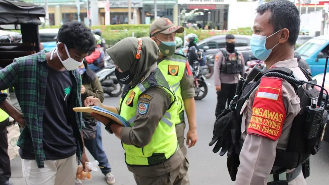 Anggota Satpol PP Kota Depok saat melakukan operasi masker di Kota Depok, Sabtu (26/12/2020)