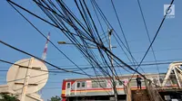 Instalasi kabel menjuntai yang berada di sekitar Jalan Gunung Sahari, Mangga Dua, Jakarta, Kamis (10/7/2019). Buruknya tata instalasi kabel di Ibu Kota menjadi penyebab banyaknya kabel semrawut, meskipun kondisi itu berbahaya serta mengganggu pemandangan. (Liputan6.com/Immanuel Antonius)