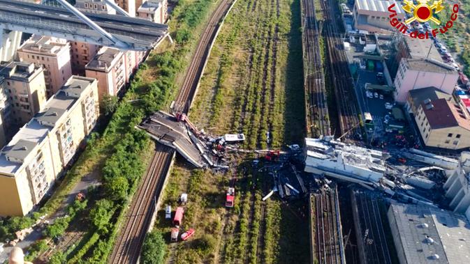 Tim penyelamat berada di antara puing-puing jembatan jalan raya Morandi yang ambruk di Genoa, Italia, Selasa (14/8). Hanya 100 meter dari total satu kilometer panjang jembatan tersebut yang dilaporkan ambruk. (Vigili Del Fuoco via AP)