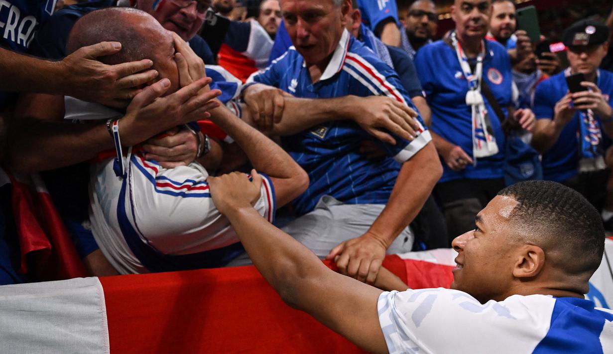 Kylian Mbappe pun langsung menghampiri tribun penonton untuk meminta maaf langsung kepada suporter yang menjadi korban dari insiden tersebut. Terlihat sang penonton hanya bisa memegang hidungnya yang sakit terkena bola tendangan Mbappe. (AFP/Kirill Kudryavtsev)
