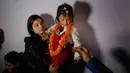 Nihira Bajracharya digendong ibunya saat dibawa untuk menjadi Dewi Hidup atau Kumari di kuil Hindu Patan, Lalitpur, Nepal (5/2). Nihira Bajracharya akan menjadi Kumari setelah pendahulunya pensiun karena mencapai pubertas. (AP Photo / Niranjan Shrestha)