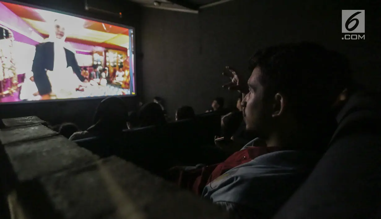 Penyandang tunanetra serius menyimak alur cerita yang diceritakan relawan bisik saat menyaksikan Bioskop Bisik di Pavilliun 28, Jakarta, Minggu (14/1). Penyandang tunanetra pun dapat merasakan emosi yang ada di film tersebut. (Liputan6.com/Faizal Fanani)
