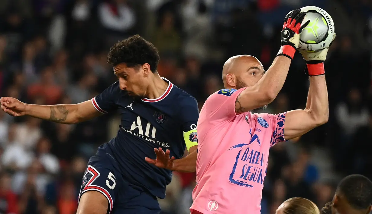 <p>Kiper Troyes, Jessy Moulin (kanan) meraih bola di sebelah bek Paris Saint Germain (PSG) Marquinhos pada matchday ke-36 Ligue 1 musim 2021-22 di Parc de Princes pada laga lanjuta Ligue 1, Senin (9/5/2022) dini hari WIB. PSG harus puas meraih hasil imbang 2-2 saat menjamu klub papan bawah, Troyes. (FRANCK FIFE / AFP)</p>