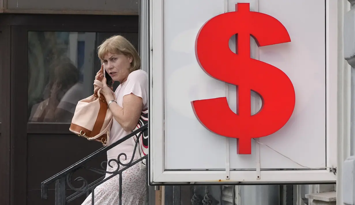 <p>Seorang wanita meninggalkan kantor penukaran mata uang di St. Petersburg, Rusia, Kamis (6/7/2023). Presiden Rusia Vladimir Putin mengatakan ekonomi Rusia berkinerja lebih baik dari yang diperkirakan. (AP Photo/Dmitri Lovetsky)</p>