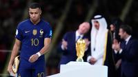 Pemain Prancis Kylian Mbappe berjalan dengan membawa trofi penghargaan Sepatu Emas usai melawan Argentina pada pertandingan sepak bola final Piala Dunia 2022 di Stadion Lusail, Lusail, Qatar, 18 Desember 2022. Kylian Mbappe berhak membawa pulang trofi penghargaan Sepatu Emas setelah menjadi pencetak gol terbanyak selama gelaran Piala Dunia 2022. (AP Photo/Natacha Pisarenko)