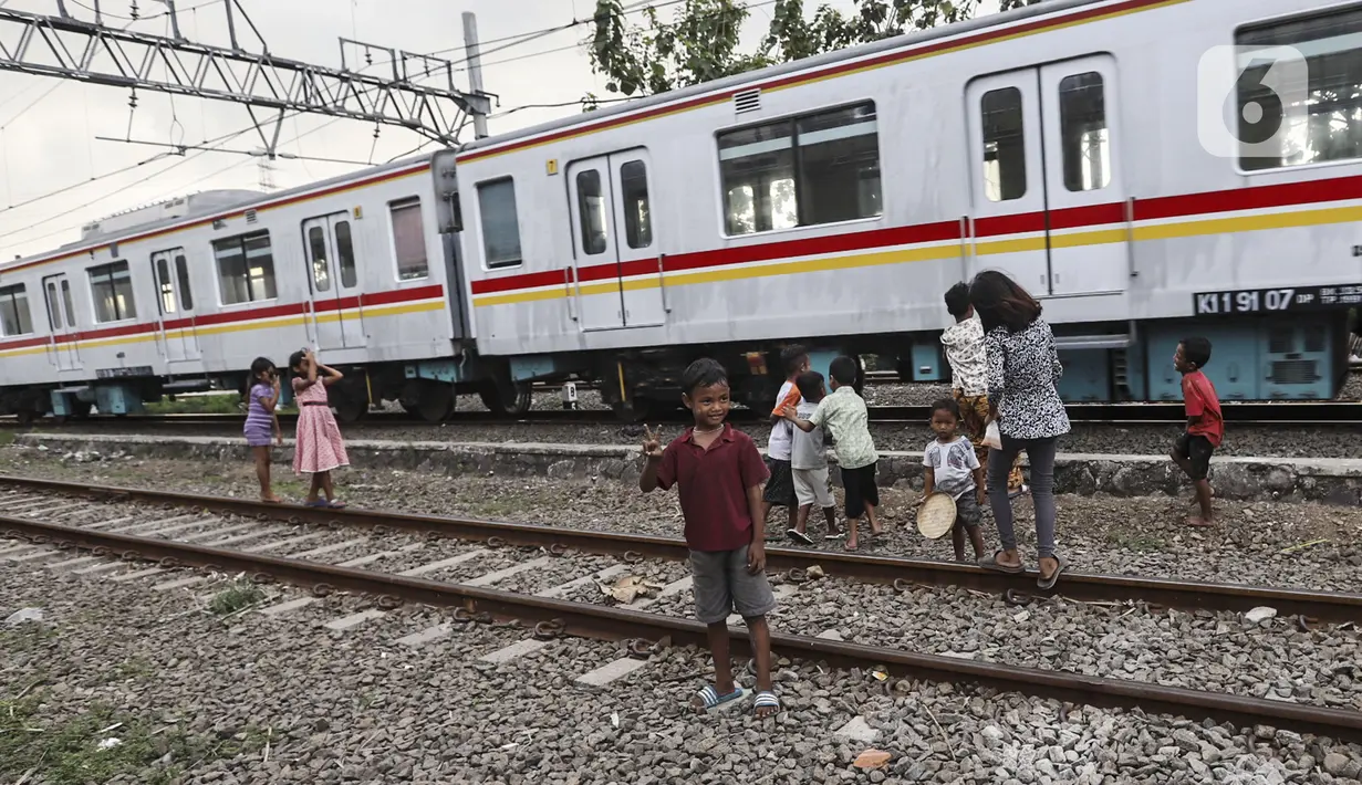 Anak-anak bermain di tengah perlintasan kereta api kawasan Ancol, Jakarta Utara, Kamis (19/5/2022). Data Kementerian Kesehatan pada 17 Mei 2022 mengungkapkan, enam orang meninggal karena diduga terjangkit hepatitis akut yang belum diketahui penyebabnya alias hepatitis misterius. (Liputan6.com/Johan Tallo)