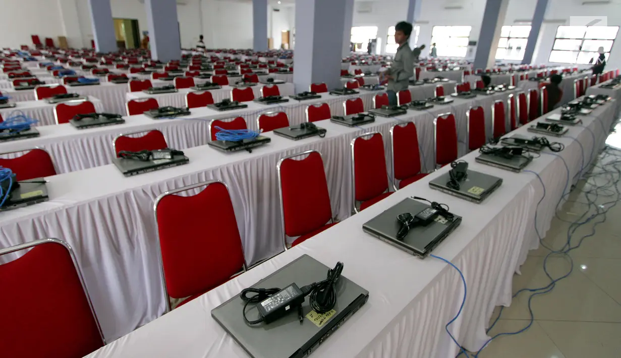 Teknisi menginstal laptop untuk tes calon pegawai negeri sipil (CPNS) di GOR Kelapa Gading, Jakarta Utara, Jumat (26/10). Tempat ini akan menjadi lokasi tes CPNS yang akan dilangsungkan pada Sabtu, 26 Oktober 2018. (Liputan6.com/JohanTallo)