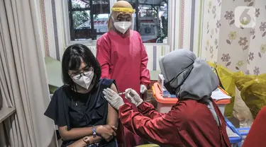 Vaksinator menyuntikkan vaksin Moderna saat vaksinasi dosis ketiga atau booster kepada tenaga kesehatan di Puskesmas Kecamatan Cilincing, Jakarta Utara, Senin (9/8/2021). Vaksinasi booster tersebut dimaksudkan untuk memberikan proteksi tambahan kepada tenaga kesehatan. (merdeka.com/Iqbal S. Nugroho)