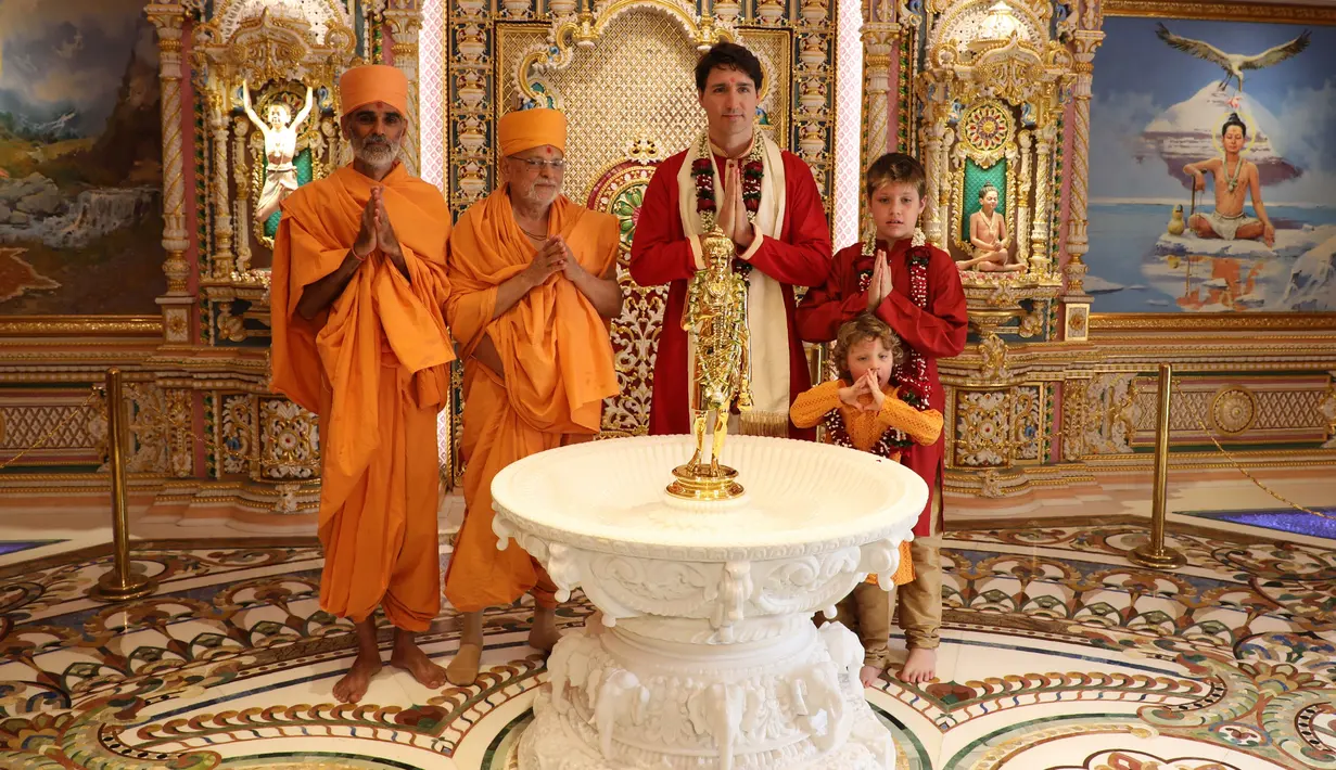 Perdana Menteri Kanada Justin Trudeau dan dua anaknya berfoto bersama pemuka agama setempat saat mengunjungi Kuil Swaminarayan Akshardham, India (19/2). (AFP Photo/Swaminarayan Akshardham Temple)