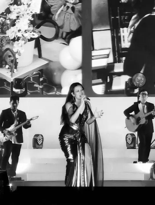 Tampil glamor, Raisa kenakan slit dress silver dengan aksen slevee [instagram/npmalina]