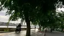 Warga mengendarai motornya melintasi trotoar di Danau Sunter, Jakarta, Jumat (19/1). Hal ini dikerenakan kurangnya kesadaran warga yang akhirnya merugikan pengguna trotoar semestinya, yaitu pejalan kaki. (Liputan6.com/Immanuel Antonius)