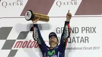 Momen kesuksesan pembalap Movistar Yamaha, Maverick Vinales, saat merebut podium juara MotoGP Qatar 2017. (Karim JAAFAR / AFP)