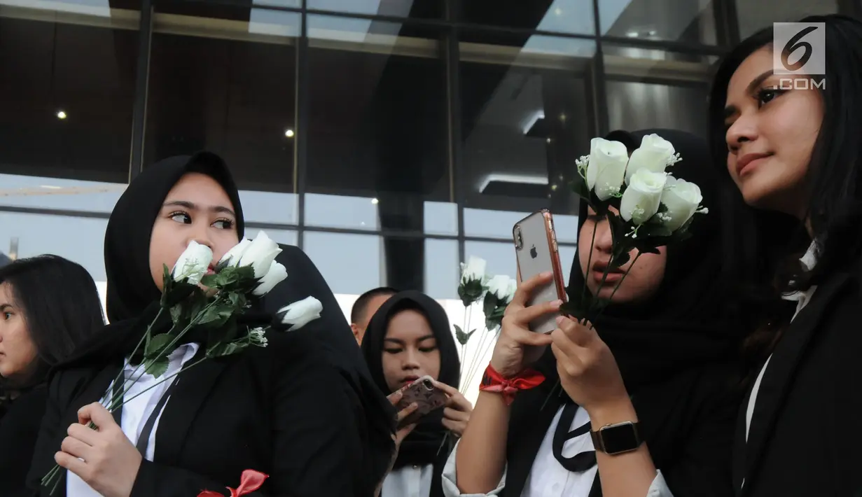 Sejumlah wanita membawa bunga mawar menyambut kedatangan penyidik senior KPK, Novel Baswedan saat masuk kerja kembali di gedung KPK, Jakarta, Jumat (27/7). Novel absen 16 bulan lantaran berobat matanya setelah diserang air keras. (Merdeka.com/Dwi Narwoko)