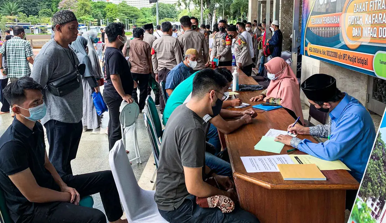 <p>Petugas menerima pembayaran zakat fitrah dari umat muslim di Masjid Istiqlal, Jakarta, Jumat (29/4/2022). Panitia Zakat Masjid Istiqlal mulai membuka layanan pembayaran zakat fitrah dengan pembayaran senilai Rp 50 ribu atau 3,5 liter beras. (Liputan6.com/Faizal Fanani)</p>