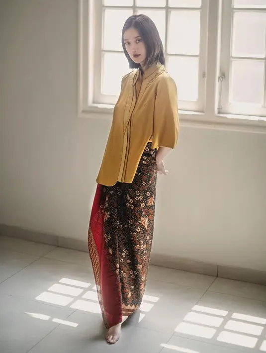 Untuk outfit kondangan sederhana, Binhpuse memadukan Tumeric Gold Blouse dengan kain batik. Menampilkan siluet yang elegan dan kecantikan yang eksotis dalam satu tampilan. (instagram/binhouse_official)