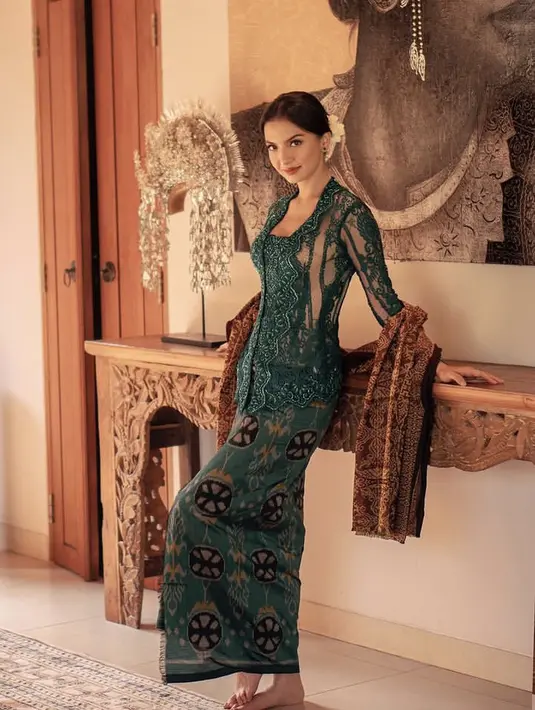 Raline tampil anggun dengan atasan kebaya hijau berpayet, dipadukan kain endek hijau dan kain songket Menggah Agung.  [@kain.menggahagung]