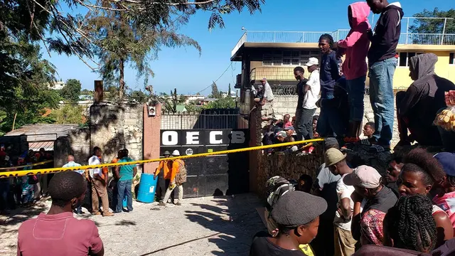 Orang-orang berdiri di luar Panti Asuhan Church of Bible Understanding di mana kebakaran terjadi, menewaskan 13 anak-anak.