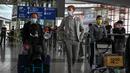 Penumpang berjalan melalui aula kedatangan untuk penerbangan internasional di Bandara Internasional Ibukota di Beijing, China, Selasa (14/3/2023). China akan kembali mengeluarkan berbagai visa untuk orang asing mulai 15 Maret besok, dalam pelonggaran besar-besaran pembatasan perjalanan sejak merebaknya pandemi Covid-19. (Photo by Jade GAO / AFP)