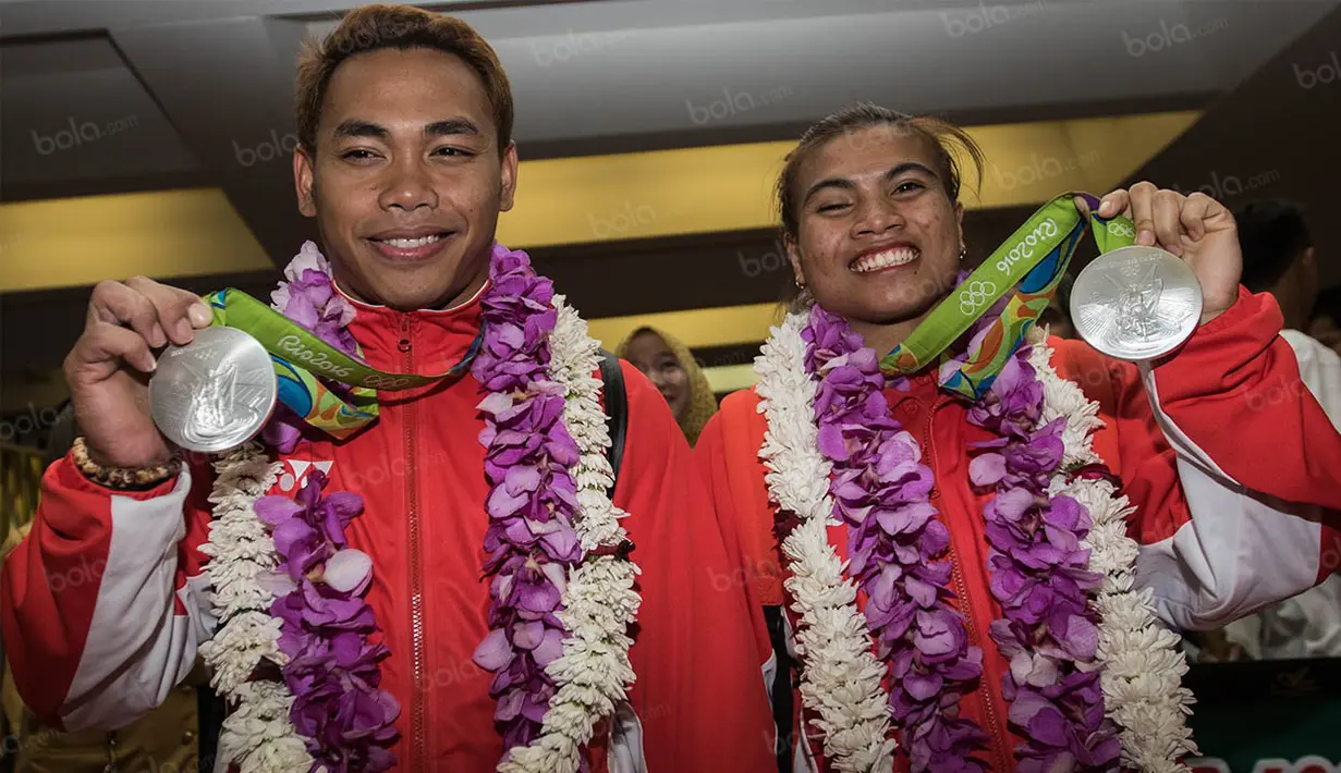 Lifter Indonesia peraih medali perak Olimpiade 2016 Rio de Janeiro, Eko Yuli dan Sri Wahyuni (kanan), tiba di Bandara Soekarno-Hatta, Tanggerang, Banten, Minggu (14/8/2016). (Bola.com/Vitalis Yogi Trisna)