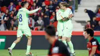 Gelandang Barcelona asal Belanda #21, Frenkie de Jong (Kanan), merayakan gol keempat timnya bersama penyerang Barcelona asal Brasil #11, Raphinha, dan gelandang Barcelona asal Spanyol #8, Pedri (Kiri), selama pertandingan liga Spanyol antara RCD Mallorca dan FC Barcelona di stadion Mallorca Son Moix di Palma de Mallorca, Rabu dini hari WIB (4/12/2024). (JAIME REINA/AFP)