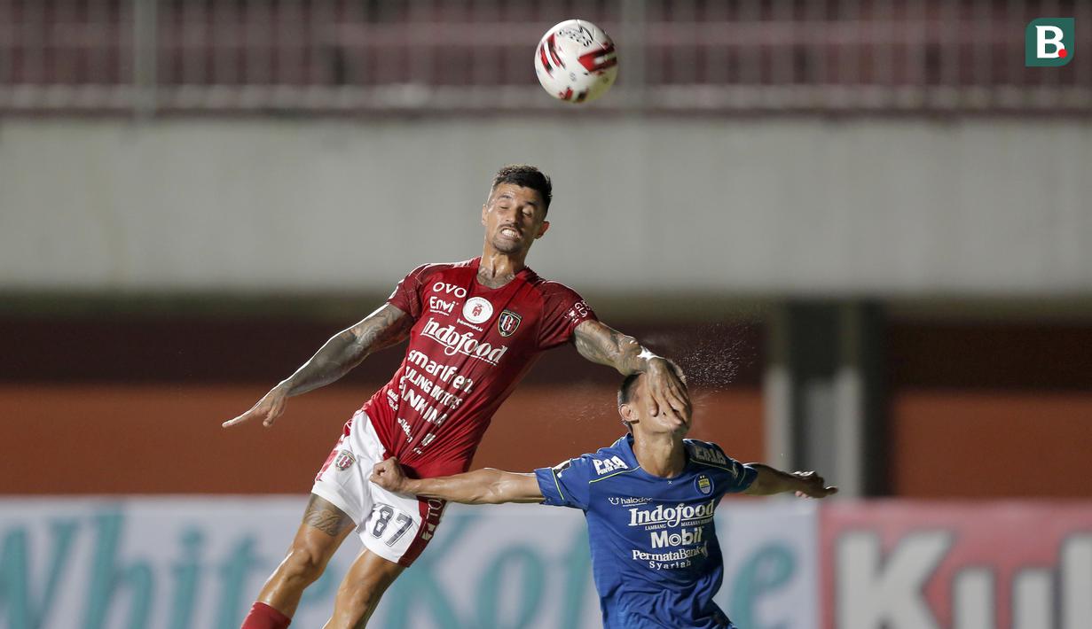 Pemain Bali United, Stefano Lilipaly (kiri), berebut bola dengan pemain Persib Bandung, Henhen Herdiana, dalam pertandingan Babak Penyisihan Piala Menpora 2021 Grup D di Stadion Maguwoharjo, Sleman. Rabu (24/3/2021). (Foto: Bola.com/Arief Bagus)