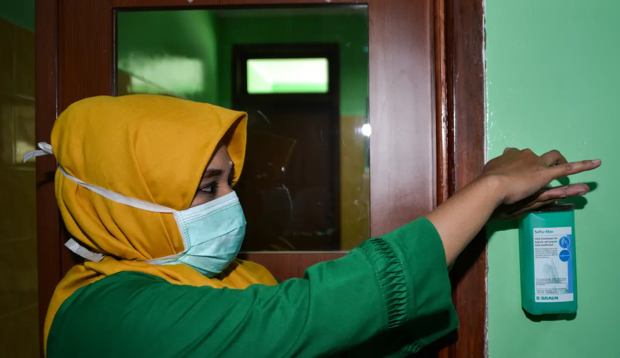 Petugas medis dengan mengenakan masker mencuci tangan di ruang isolasi di sebuah rumah sakit di Banda Aceh, Selasa (3/3/2020). Di Aceh, dua rumah sakit menjadi rujukan pasien virus Corona, yakni Rumah Sakit Umum dr Zainoel Abidin, Banda Aceh dan RSUD Cut Meutia, Aceh Utara. (CHAIDEER MAHYUDDIN/AFP)