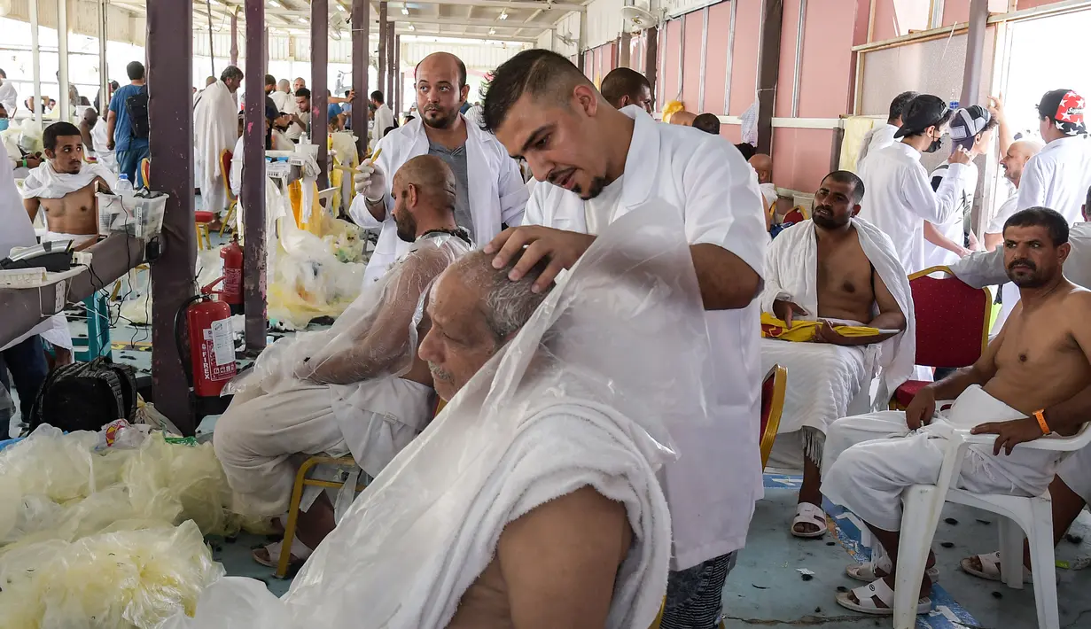 Jemaah haji mencukur rambut kepala atau tahalul usai melaksanakan lempar jumrah, Mina, Arab Saudi, Minggu (11/8/2019). Tahalul adalah kegiatan mencukur rambut setelah kegiatan ibadah haji. (FETHI BELAID/AFP)