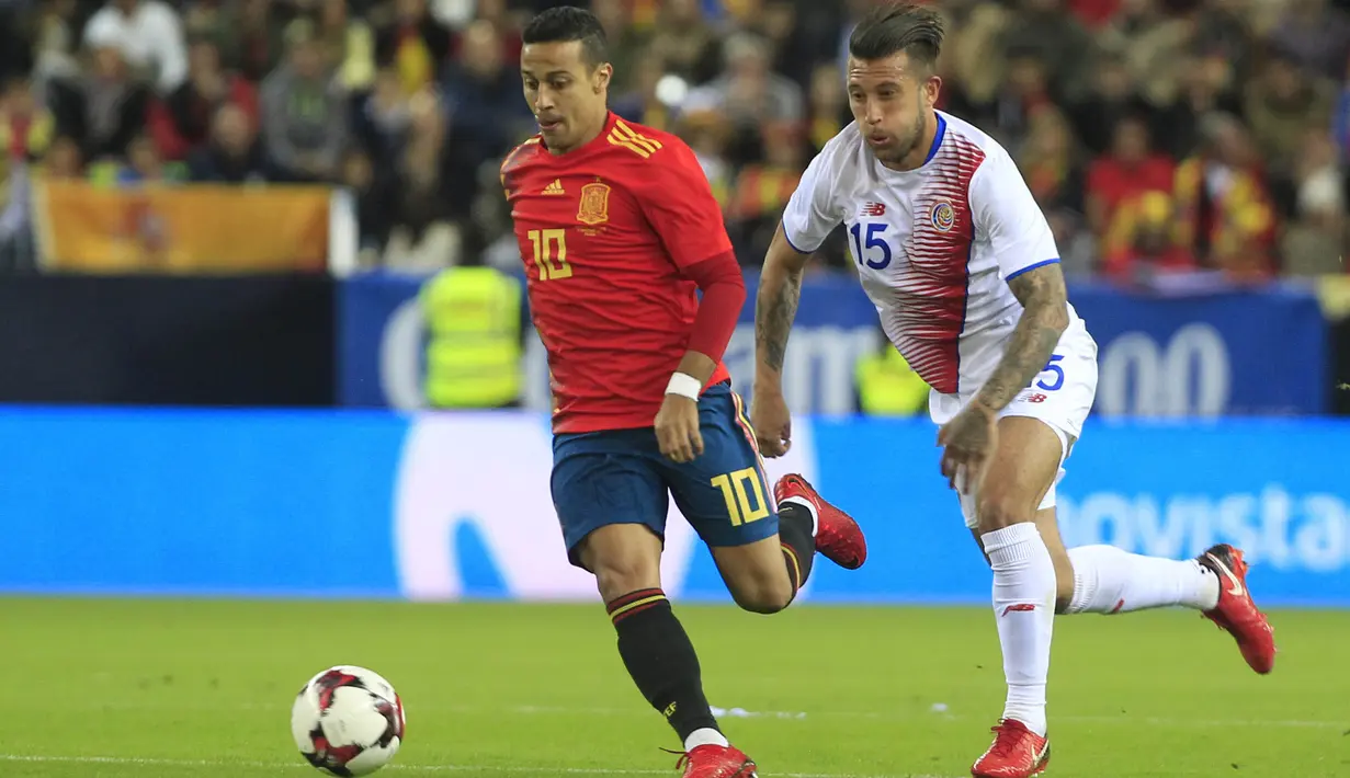 Gelandang Spanyol, Thiago Alcantara, berusaha melewati bek osta Rika, Francisco Calvo, pada laga persahabatan di Stadion La Rosaleda, Sabtu (11/11/2017). Spanyol menang 5-0 atas Kosta Rika. (AP/Miguel Morenatti)