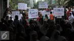 Warga penghuni kompleks Purnawirawan Korps Zeni TNI AD, Mampang Prapatan, menggelar aksi penolakan pengosongan perumahan mereka di depan gerbang komplek, Jakarta Selatan, Kamis (29/10). (Liputan6.com/Gempur M Surya)