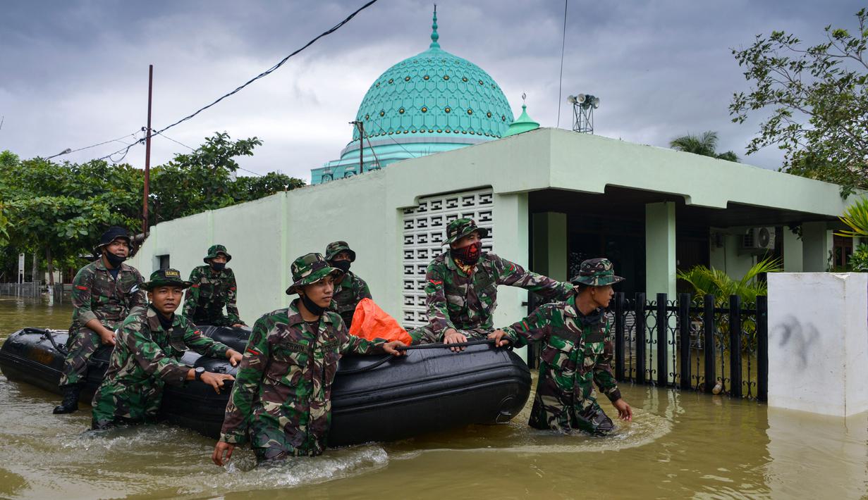 Prajurit TNI dengan perahut karet memberikan bantuan untuk warga terdampak banjir setelah tiga hari hujan lebat di Banda Aceh, Aceh, Sabtu (9/5/2020). Banjir akibat intensitas hujan tinggi mengakibatkan sebagian besar kawasan di ibu kota Provinsi Aceh digenangi air. (Photo by CHAIDEER MAHYUDDIN/AFP)