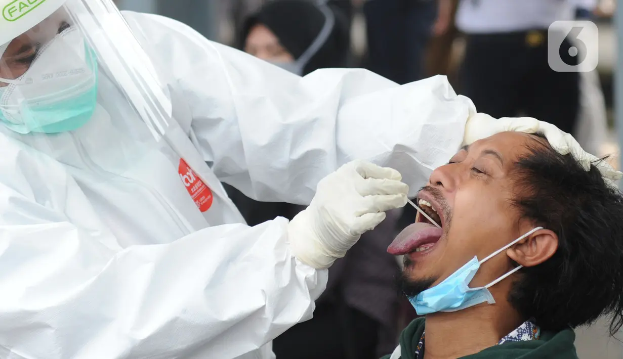 Paramedis mengambil sampel penumpang KRL Commuter Line saat tes swab di Stasiun Bojonggeder, Jawa Barat, Senin (11/05/2020).  Pemkab Bogor  melakukan tes swab  dan rapid test bagi penumpang KRL Commuter Line  dilakukan secara massal. (merdeka.com/Arie Basuki)