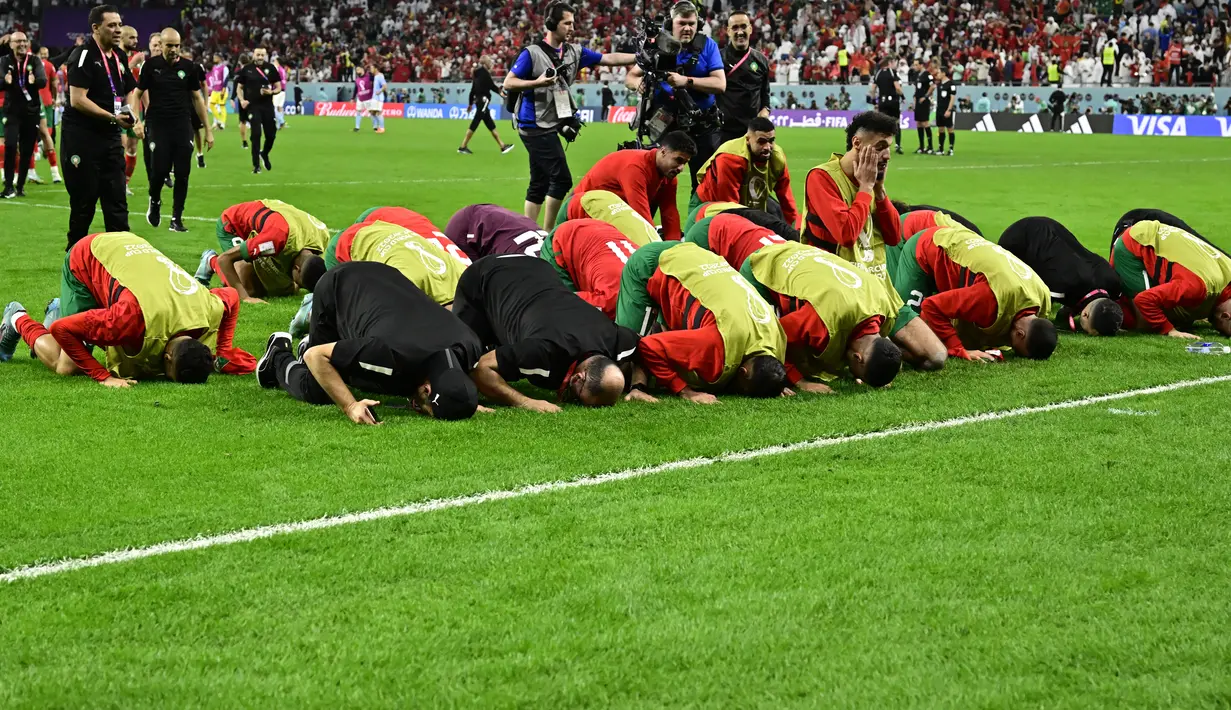 Para pemain Maroko sujud syukur merayakan kemenangan atas Spanyol  pada babak 16 besar Piala Dunia 2022 di Education City Stadium, Al Rayyan, Rabu (6/12/2022) dini hari WIB. Achraf Hakimi dkk. juga melakukan ungkapan terima kasih kepada Allah SWT itu ketika menang atas Belgia untuk melaju ke 16 besar. (JAVIER SORIANO / AFP)