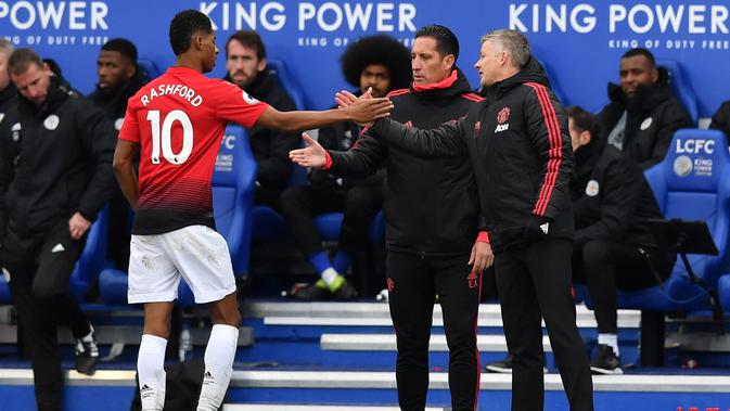 Striker MU, Marcus Rashford (kiri) berjabat tangan dengan manajer sementara MU Ole Gunnar Solskjaer (kanan) saat digantikan pada laga melawan Leicester City pada Premier League di King Power Stadium, Leicester, Minggu (3/2). (Ben STANSALL/AFP)