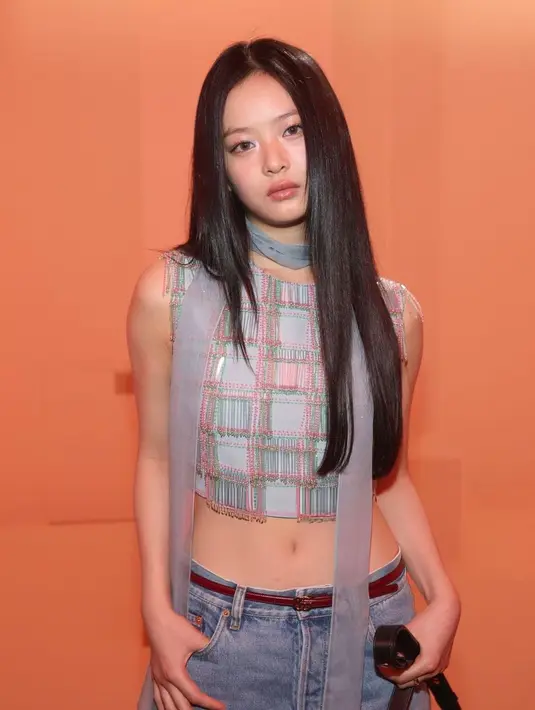 Hanni NewJeans tampil dengan look musim panas, ia mengenakan ikat pinggang tipis dengan celana jins longgar dan light-wash yang pas di pinggangnya, memperlihatkan perutnya dengan gaya Y2K.  [@newjeans.hanni]