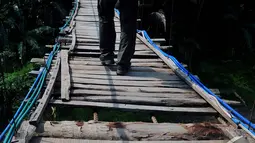Kondisi jembatan gantung Lebak yang memprihatinkan bisa membahayakan warga yang melintas diatasnya. Foto diambil pada Selasa (5/11/2014) (Liputan6.com/Johan Tallo)