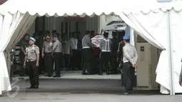 Petugas TNI dan Polisi mengeluarkan peti jenazah yang diselimuti bendera merah putih untuk dibawa masuk ke dalam ruangan RS Polri guna menjalani proses identifikasi, Jakarta, Senin (21/3/2016). (Liputan6.com/Yoppy Renato)