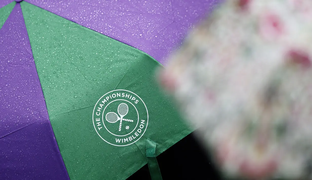 Sebuah payung berlogo kejuaraan tenis Wimbledon terlihat saat pertandingan perempat final wanita antara Garbine Muguruza Spanyol dan petenis Rusia Svetlana Kuznetsova di The All England Lawn Tennis Club,London, (11/7). (AFP Photo/Adrian Dennis)