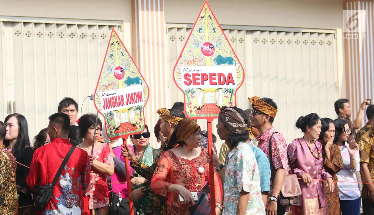 Sejumlah relawan menyaksikan prosesi kirab kereta kencana pernikahan putri Presiden Jokowi,  Kahiyang Ayu-Bobby Nasution saat menuju Gedung Graha Saba di Surakarta, Rabu (8/11). (Liputan6.com/Angga Yuniar)