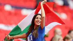 Suporter Timnas Italia mengibarkan bendera saat menyaksikan pertandingan melawan Spanyol pada laga semifinal Euro 2020 di Stadion Wembley, Rabu (7/7/2021). (Foto:AFP/Carl Recine,Pool)