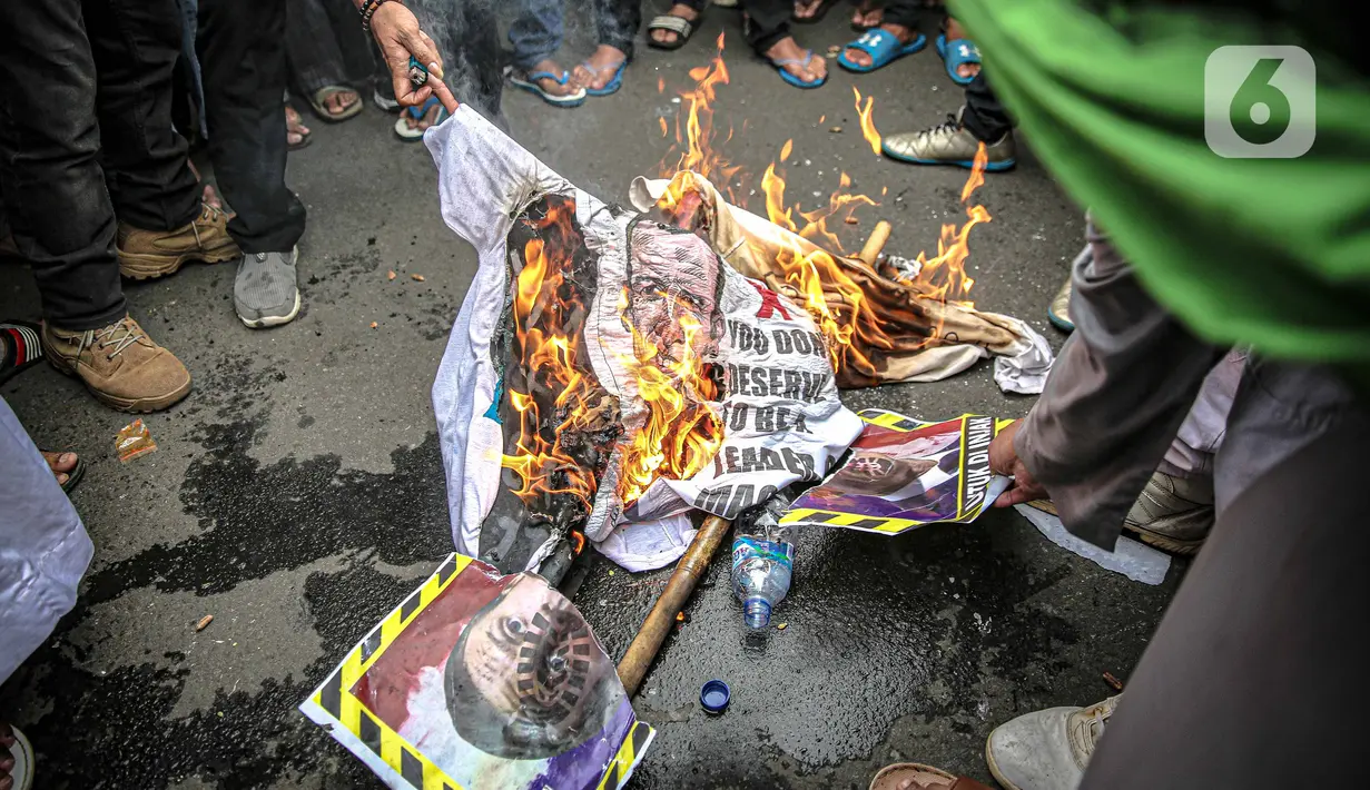 Massa dari berbagai elemen ormas Islam membakar atribut dengan foto Presiden Prancis Emmanuel Marcon di kawasan Sarinah, Jakarta, Senin (2/11/2020). Demonstrasi ini untuk mengecam Emanuel Macron atas pernyataannya yang dinilai telah menghina Islam dan Nabi Muhammad SAW. (Liputan6.com/Faizal Fanani)