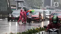 Pejalan kaki yang menggunakan payung saat hujan deras menyeberang jalan di kawasan Thamrin, Jakarta, Rabu (23/11/2022). Sejak Oktober, DKI Jakarta mulai memasuki musim penghujan yang sudah masuk ke dalam tahap ekstrem. (Liputan6.com/Faizal Fanani)
