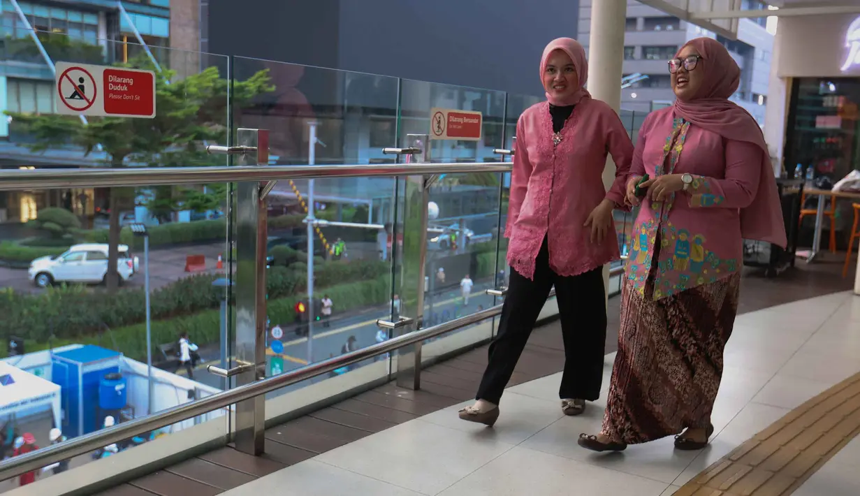 Melawan segala bentuk diskriminasi, Raden Ajeng Kartini berjuang membuka akses untuk perempuan Indonesia agar bisa berkontribusi lebih luas, bukan hanya di lingkungan domestik atau rumah tangga. Tampak dalam foto, beberapa perempuan mengenakan kebaya saat melintas di sekitar kawasan Bundaran Hotel Indonesia, Jakarta, Selasa (21/4/2026). (Kapanlagi.com/Budy Santoso)