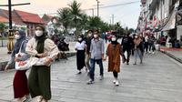 Warga sedang berkunjung ke Kota Tua, Jakarta Barat sambil mengenakan masker karena masih di tengah pandemi COVID-19. (28/8/2022) Foto: Liputan6.com/ Ade Nasihudin).