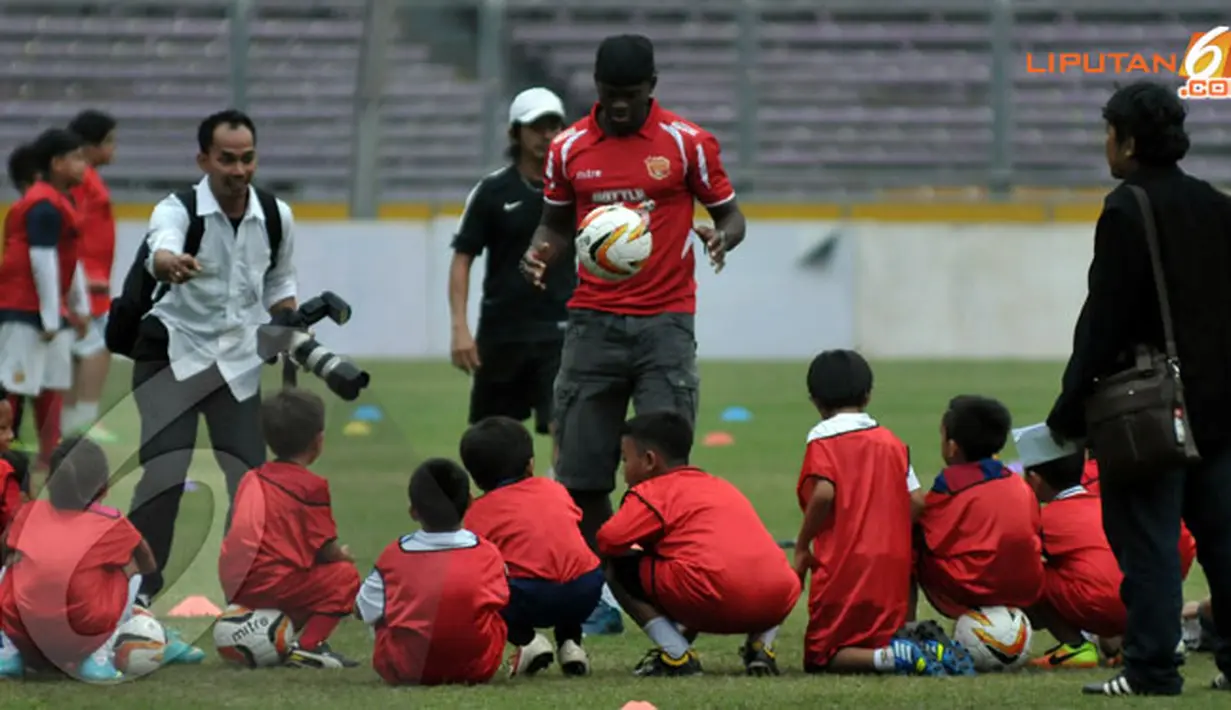 Louis Saha (tengah) memeragakan aksi dribling bola di hadapan peserta coaching clinic (Liputan6.com/ Helmi Fithriansyah)