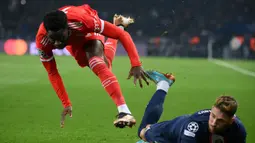 Pemain Bayern Munchen, Alphonso Davies (kiri) dijatuhkan pemain PSG, Sergio Ramos dalam laga leg pertama babak 16 besar Liga Champions 2022/2023 di Parc des Princes Stadium, Paris (14/2/2023). Namun perubahan besar terjadi dalam skema permainan sejak Alphonso Davies dimasukkan. (AFP/Franck Fife)