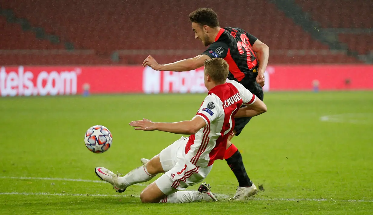 Gelandang Liverpool, Liverpool Xherdan Shaqiri melakukan tembakan yang berusaha dihentikan pemain Ajax Amsterdam, Perr Schuurs pada pertandingan pertama Grup D Liga Champions 2020 di Johan Cruijff Arena, Kamis (22/10/2020) dini hari WIB. Liverpool susah payah menang tipis 1-0 di kandang Ajax. (AP Ph